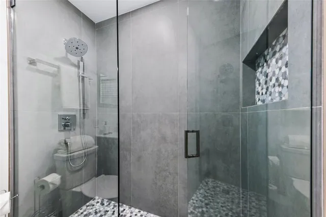 a bathroom with a shower toilet and sink