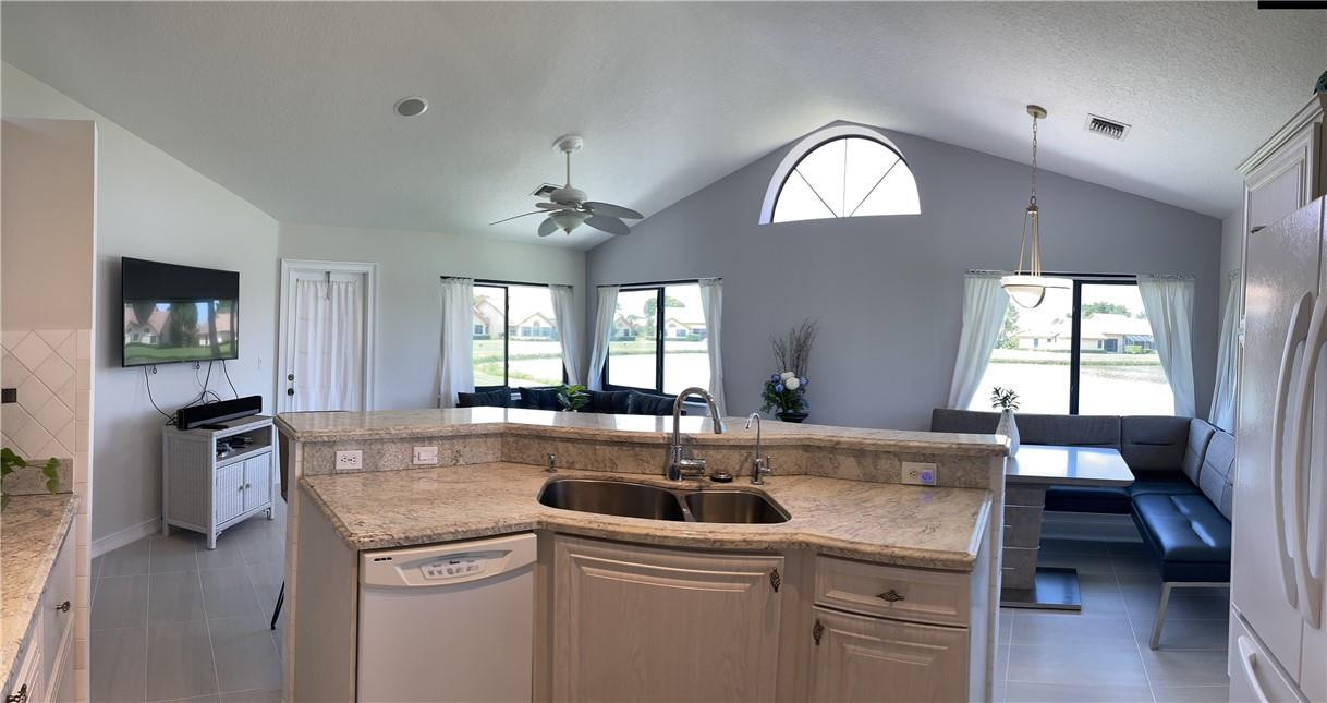 a kitchen with a stove a sink and dishwasher with wooden floor