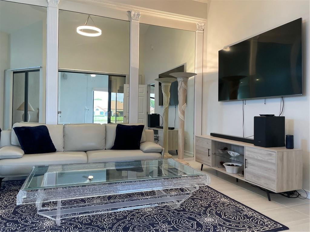 Undisclosed Address Boynton Beach, FL 33472 - Photo 11 of 41 a living room with a flat screen tv and a view of kitchen