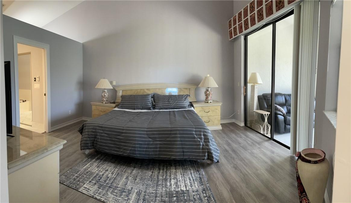 Undisclosed Address Boynton Beach, FL 33472 - Photo 19 of 41 a bedroom with a bed next to a large window with wooden floor