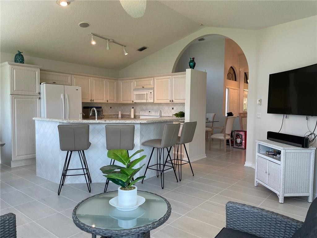 Undisclosed Address Boynton Beach, FL 33472 - Photo 2 of 41 a living room with stainless steel appliances furniture a dining table and a fireplace