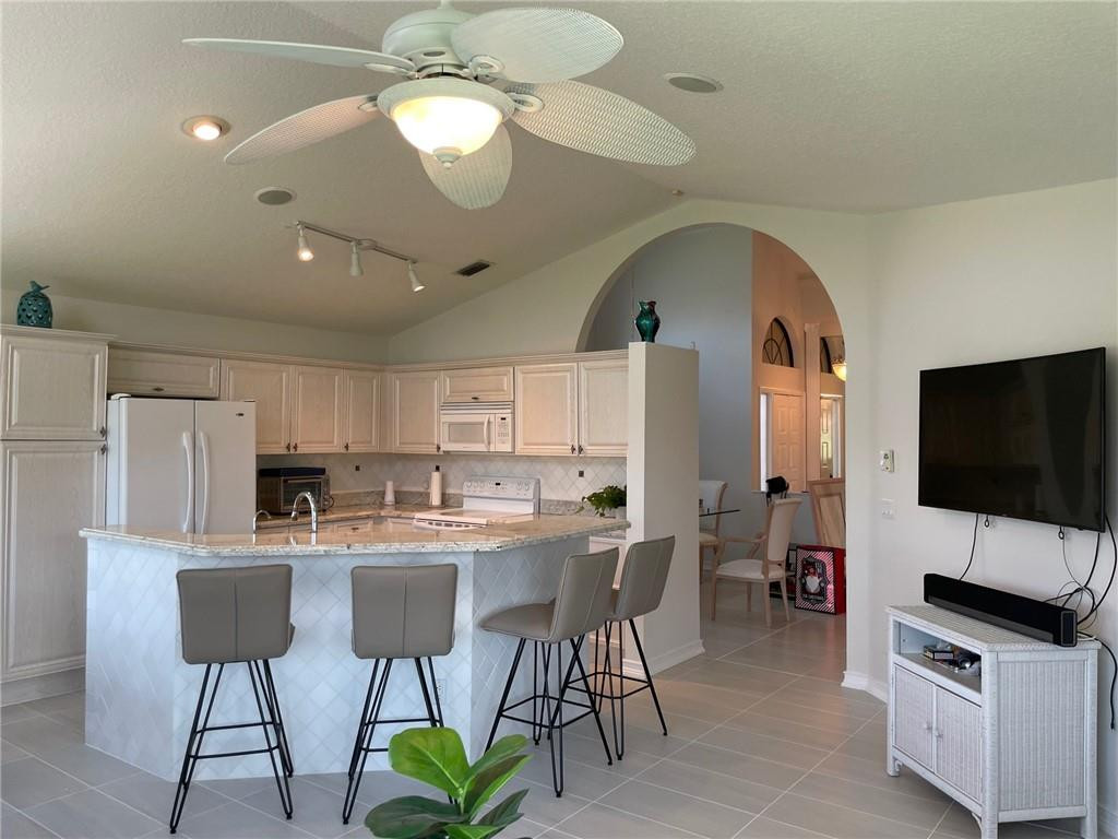 Undisclosed Address Boynton Beach, FL 33472 - Photo 3 of 41 a kitchen with stainless steel appliances a dining table chairs stove refrigerator and cabinets