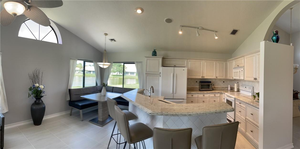 Undisclosed Address Boynton Beach, FL 33472 - Photo 6 of 41 a kitchen with kitchen island granite countertop a sink cabinets and refrigerator