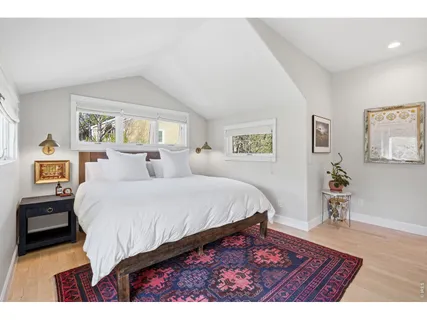 a living room with a bed furniture and paintings on the wall