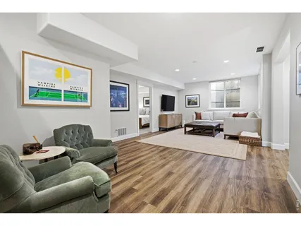 a living room with furniture flat screen tv and a window
