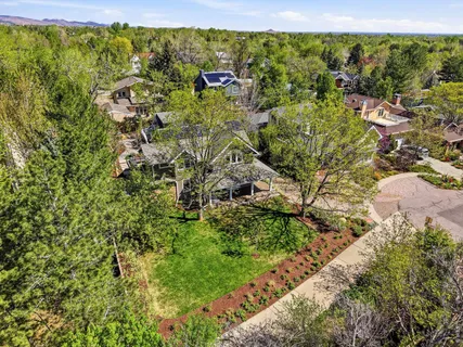 an aerial view of residential houses with outdoor space and trees