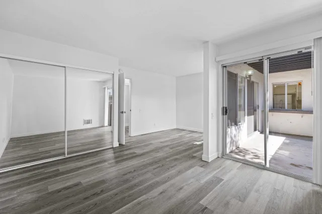 an empty room with wooden floor and door