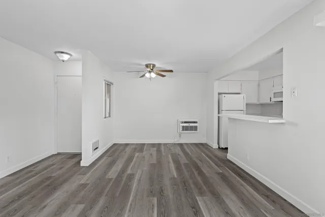 a view of a room with wooden floor cabinet and a ceiling fan