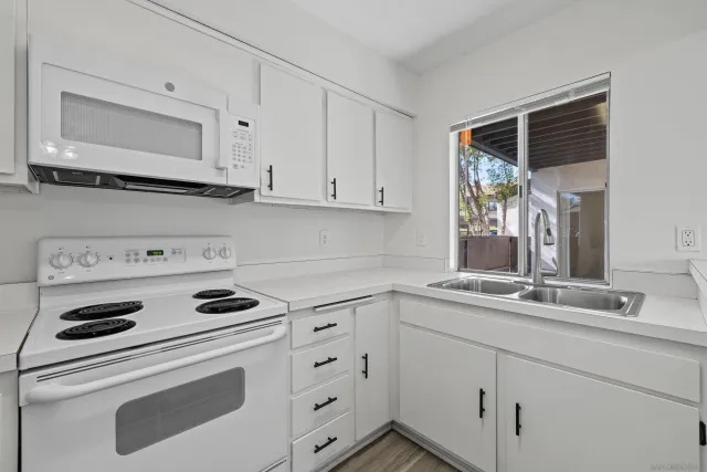 a kitchen with cabinets appliances a sink and a window