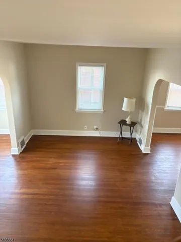 a view of a livingroom with wooden floor and a chair