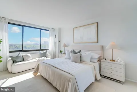 a bedroom with bed and large window