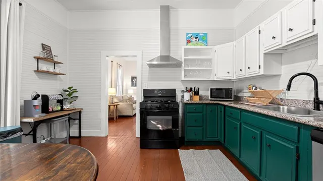 a kitchen with stainless steel appliances granite countertop a refrigerator a stove and a sink with wooden cabinets