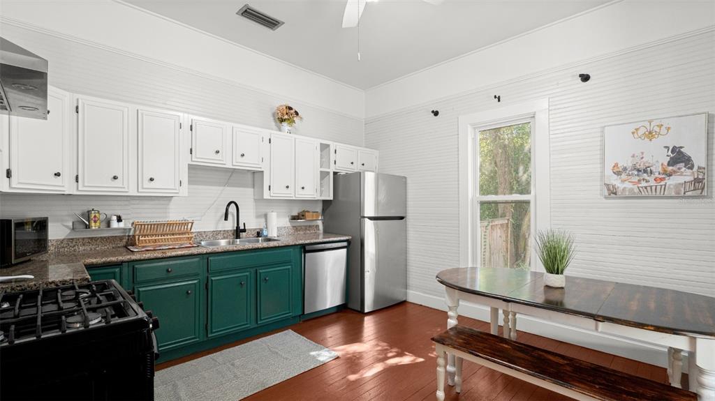 101 Northeast 9th Street Gainesville, FL 32601 - Photo 9 of 35 a kitchen with stainless steel appliances a stove a sink and a refrigerator