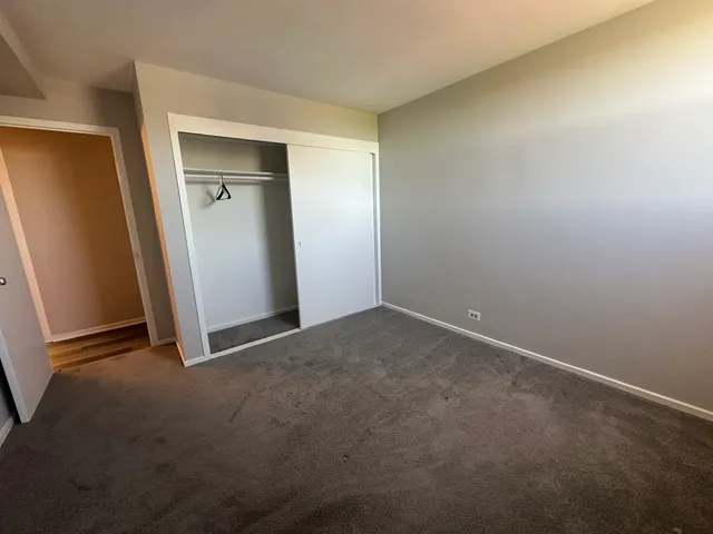 an empty room with closet and mirror