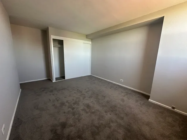 an empty room with closet and mirror