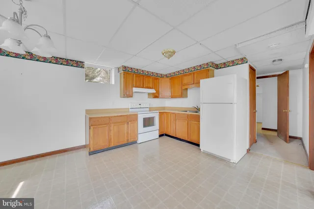 a utility room with refrigerator and windows