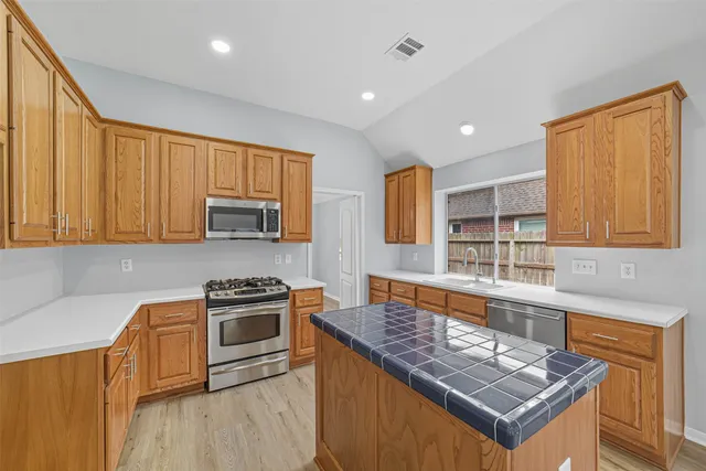 a kitchen with stainless steel appliances granite countertop wooden cabinets stove and sink