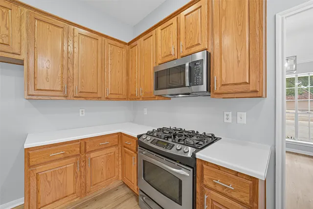 a kitchen with stainless steel appliances granite countertop white cabinets and a stove top oven