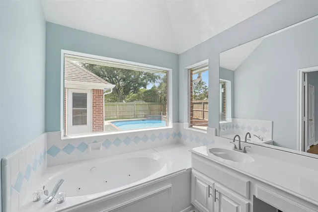 a bathroom with a tub sink and mirror