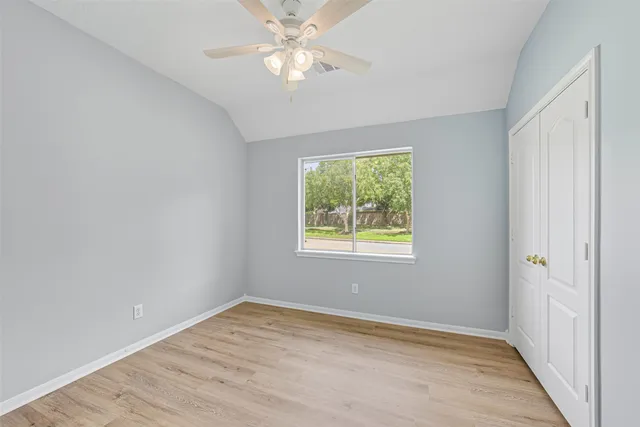 an empty room with a window and closet area