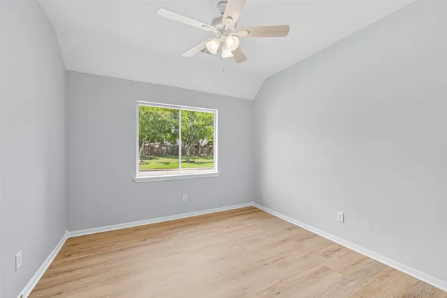 an empty room with a window and a ceiling fan