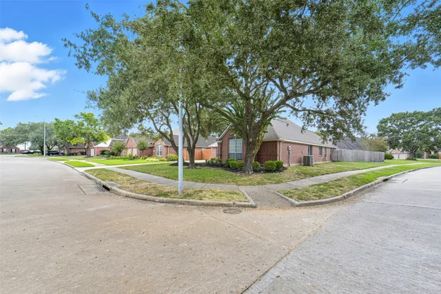 a view of a house with a big yard and large trees