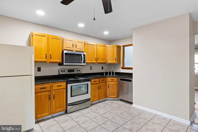 a kitchen with stainless steel appliances granite countertop a refrigerator a stove top oven a sink and dishwasher
