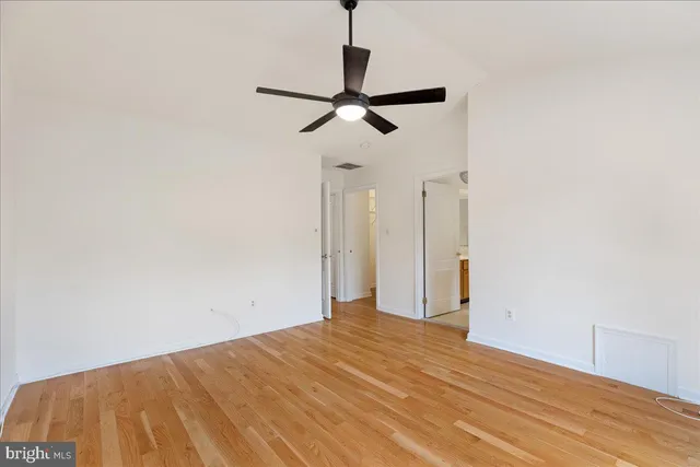 a view of empty room with wooden floor