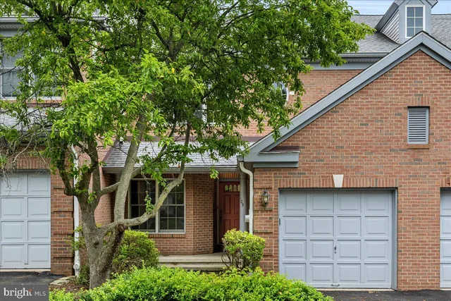 a front view of a house with a tree