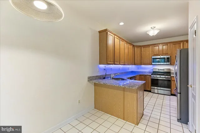 a kitchen with stainless steel appliances granite countertop a stove a refrigerator and a microwave