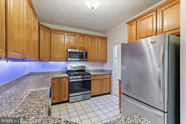 a kitchen with stainless steel appliances granite countertop a refrigerator stove and microwave