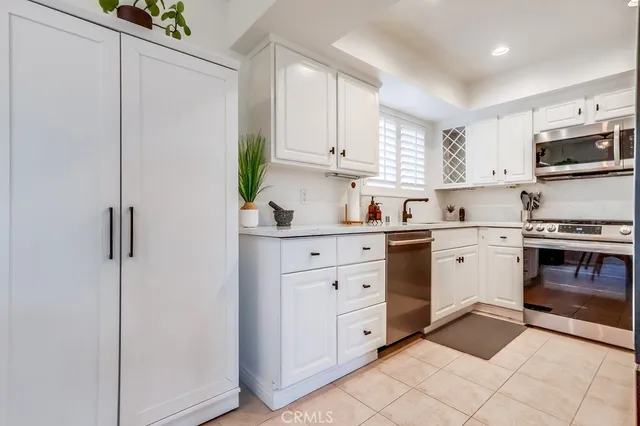 a kitchen with white cabinets and white appliances