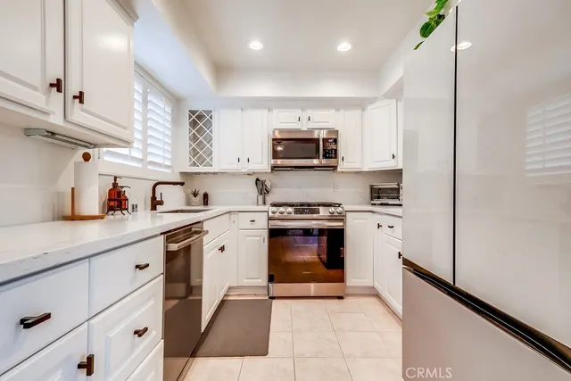 a kitchen with stainless steel appliances granite countertop a refrigerator and a stove top oven
