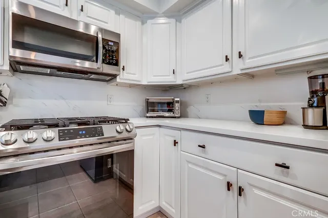 a kitchen with stainless steel appliances granite countertop a stove a microwave and cabinets