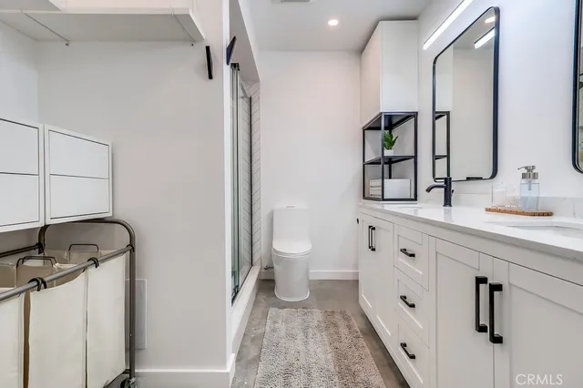 a bathroom with a double vanity sink mirror and toilet