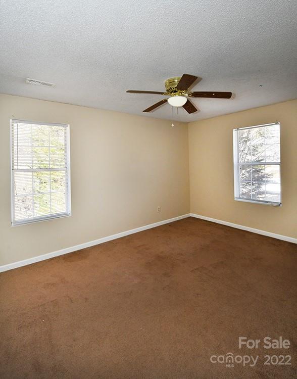 104 Queensbury Road Troutman, NC 28166 - Photo 14 of 24 an empty room with a window and a ceiling fan
