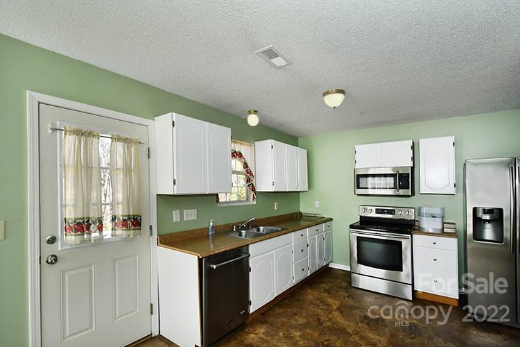 104 Queensbury Road Troutman, NC 28166 - Photo 4 of 24 a kitchen with granite countertop a stove top oven sink and cabinets
