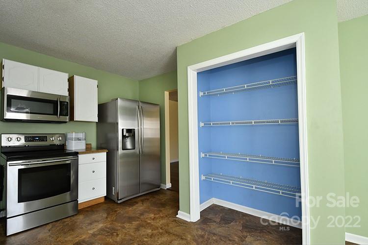 104 Queensbury Road Troutman, NC 28166 - Photo 5 of 24 a kitchen with a refrigerator and a stove top oven