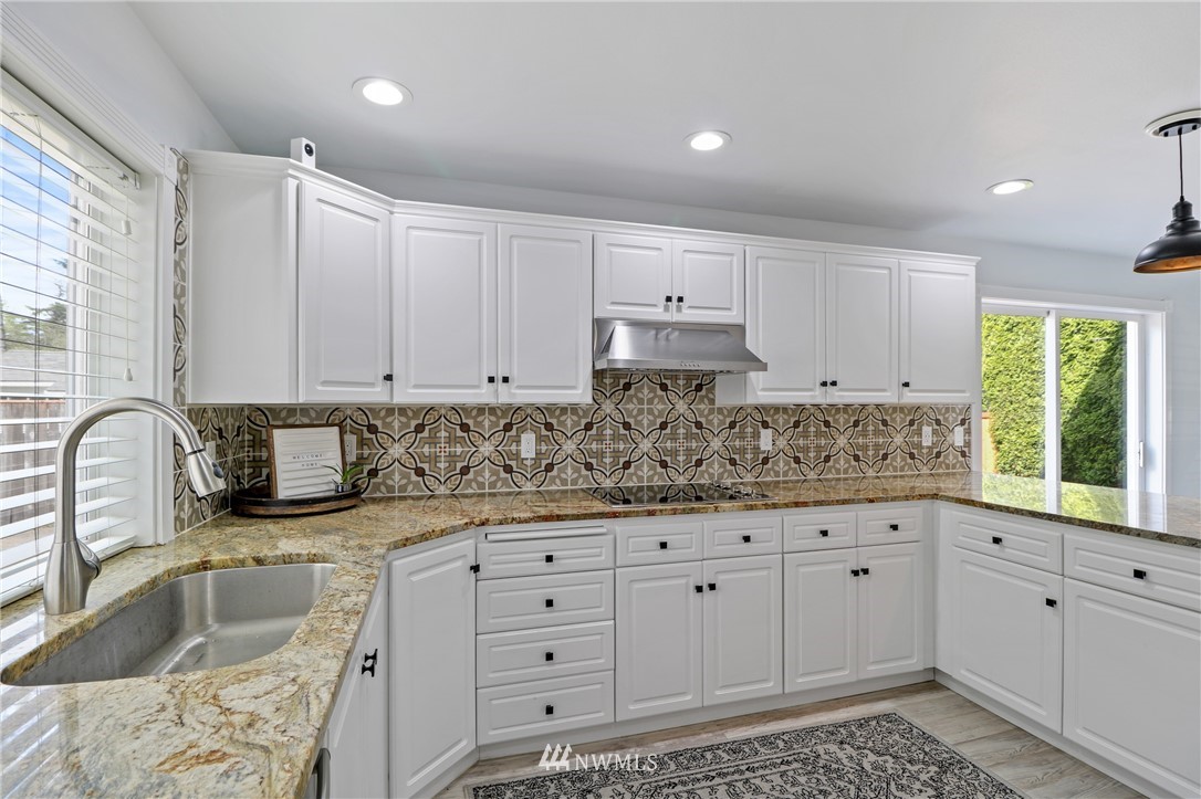 706 2nd Street Steilacoom, WA 98388 - Photo 12 of 35 a kitchen with granite countertop a sink and white cabinets