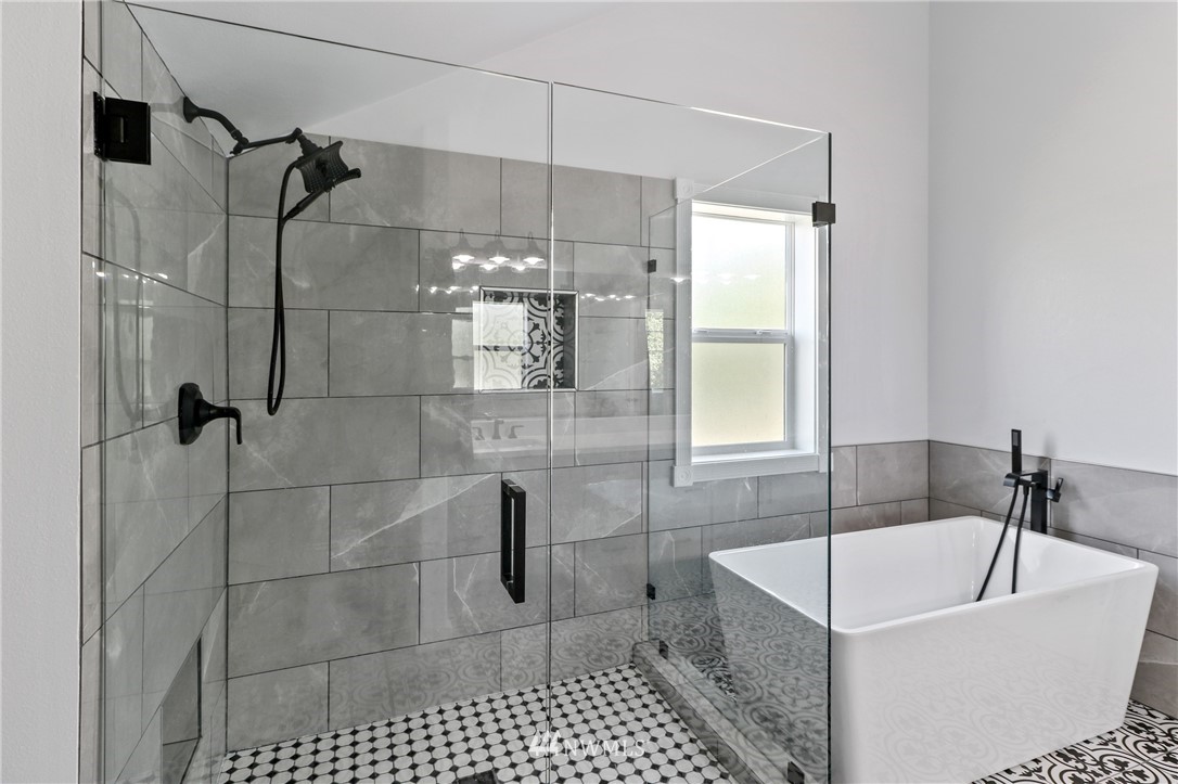 706 2nd Street Steilacoom, WA 98388 - Photo 28 of 35 a bathroom with a bathtub a mirror a shower and vanity