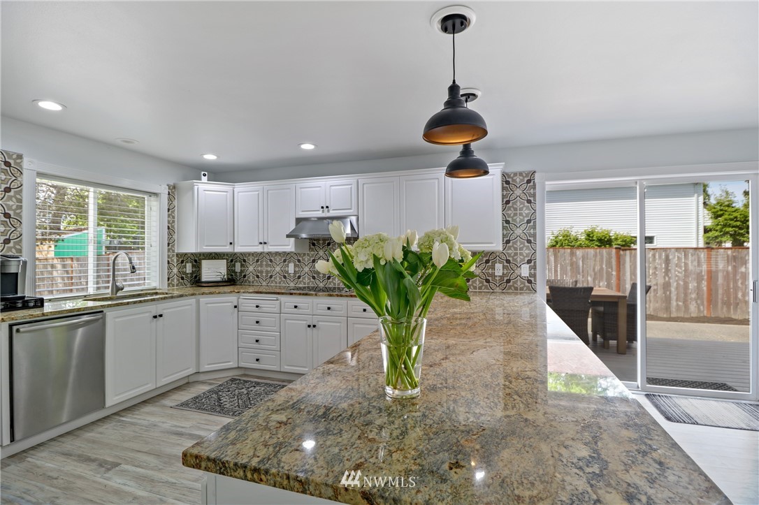 706 2nd Street Steilacoom, WA 98388 - Photo 10 of 35 a kitchen with white cabinets and chandelier