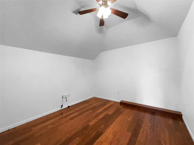 a view of a room with wooden floor and fan