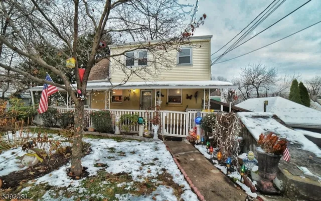 a view of a house with a large tree and a yard