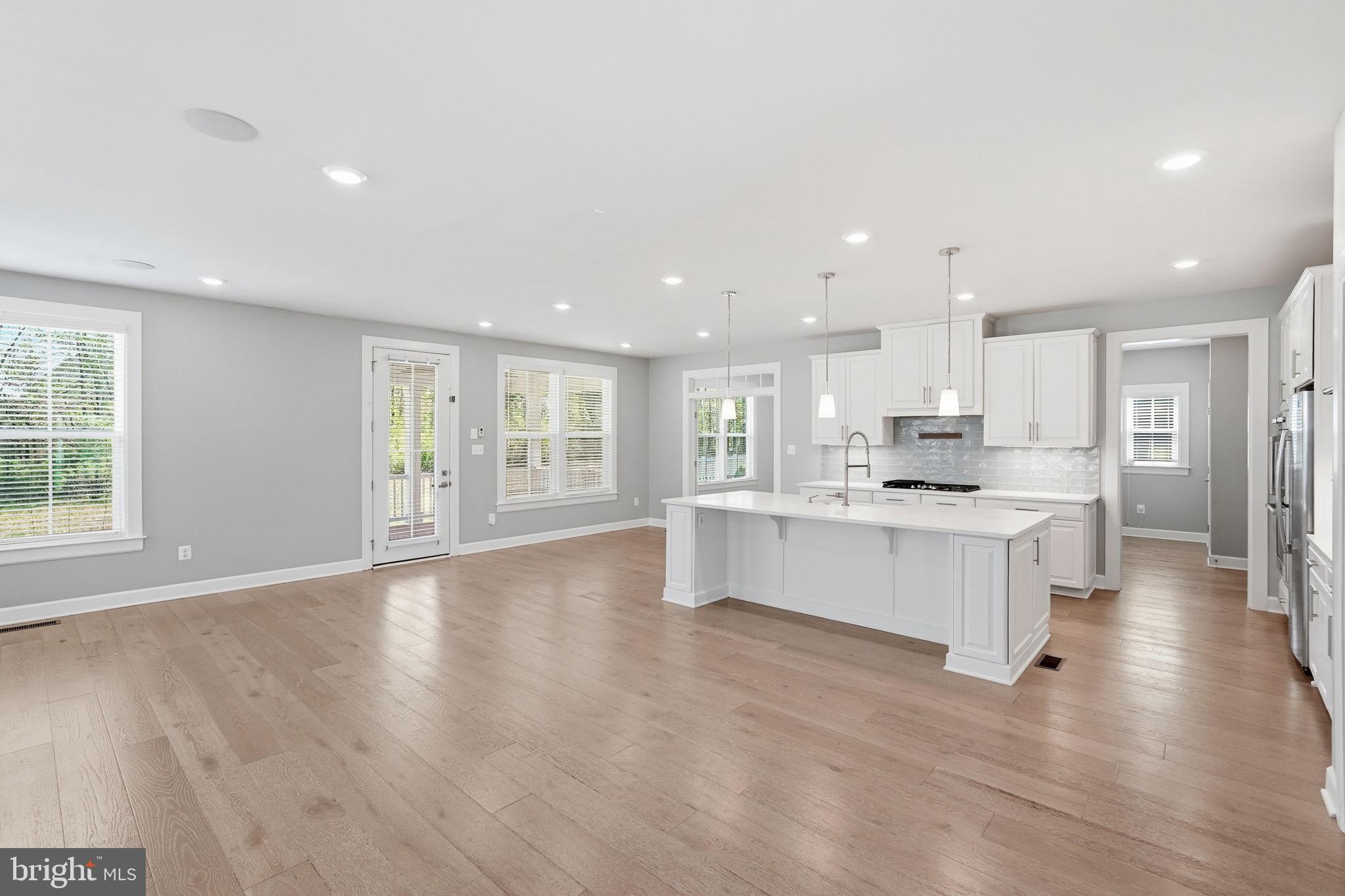 23648 Amesfield Place Aldie, VA 20105 - Photo 10 of 41 a large white kitchen with kitchen island a sink a center island stainless steel appliances and a cabinets