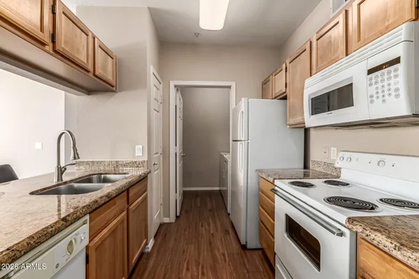 a kitchen with granite countertop a sink stainless steel appliances and cabinets