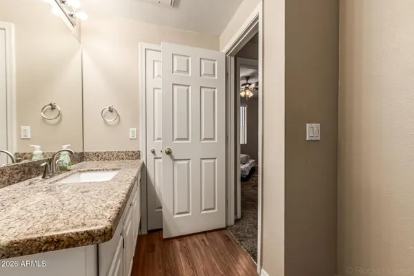 a bathroom with a granite countertop sink and a mirror