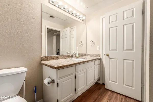 a bathroom with a granite countertop sink and a mirror