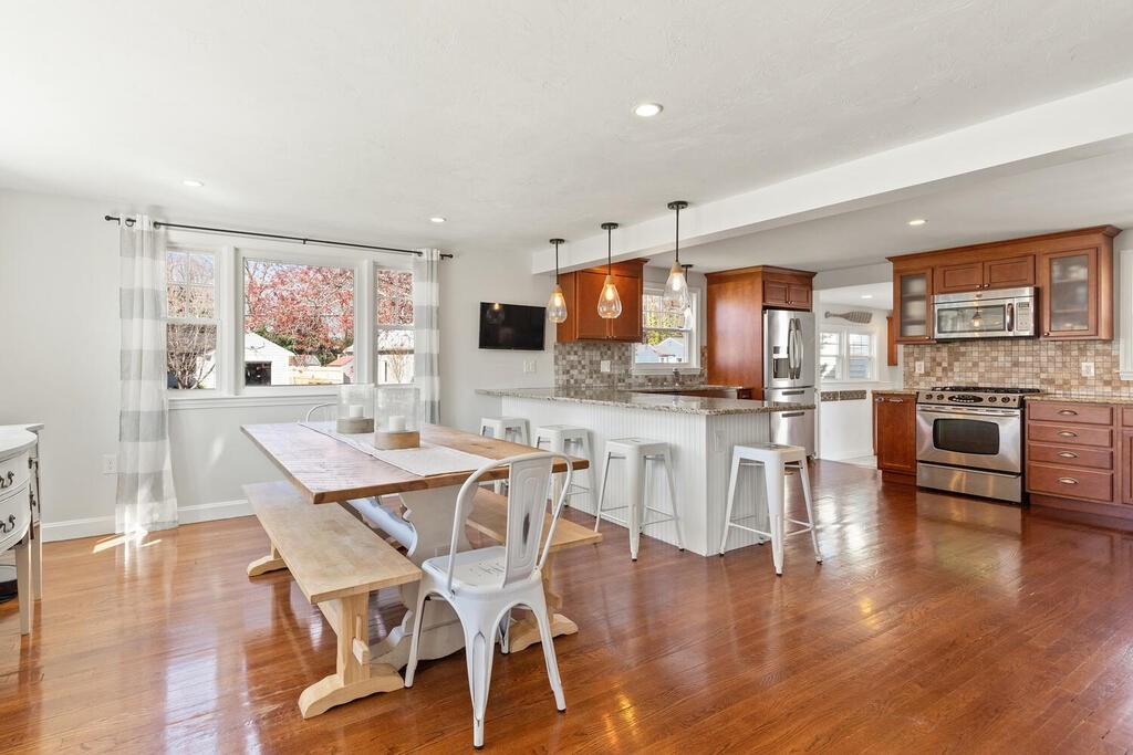4 Crescent Road Hamilton, MA 01982 - Photo 7 of 29 a dining area with stainless steel appliances kitchen island granite countertop a stove top oven a dining table and chairs