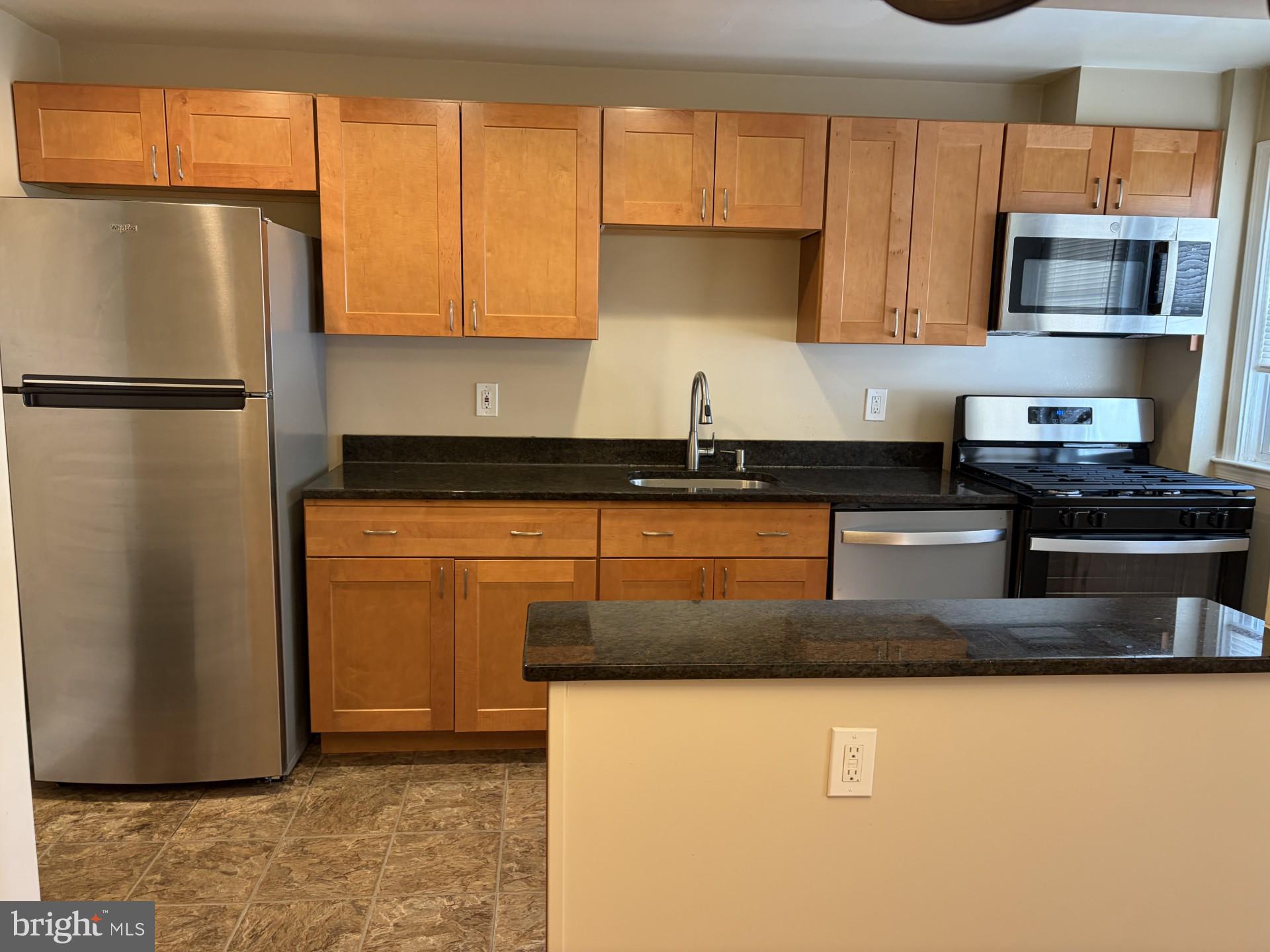 586 Lucia Avenue Baltimore, MD 21229 - Photo 2 of 14 a kitchen with stainless steel appliances granite countertop a refrigerator a stove a sink and a microwave