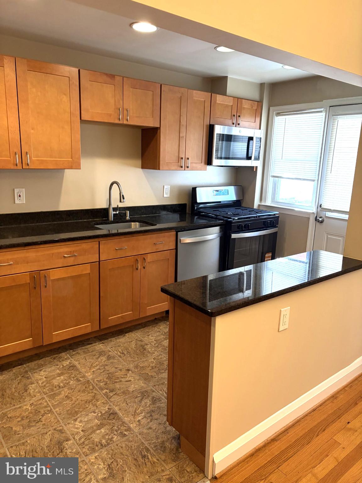 586 Lucia Avenue Baltimore, MD 21229 - Photo 3 of 14 a kitchen with stainless steel appliances granite countertop a sink stove and microwave